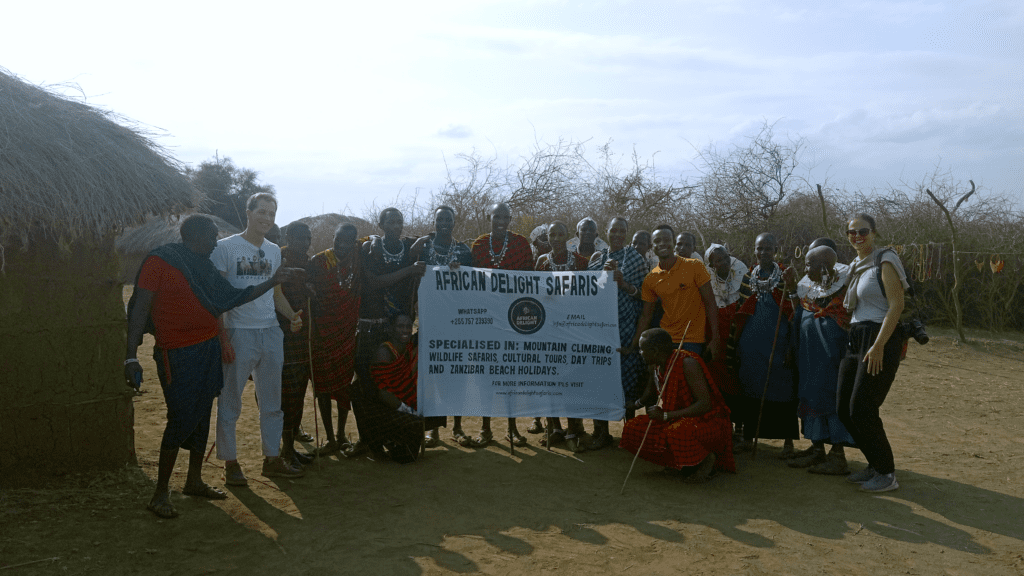 Standing with a couple of tourists and a group of Maasai warriors at Olpopongi Maasai Village
