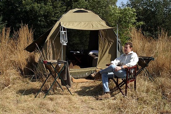 man sitting outside a camping tent