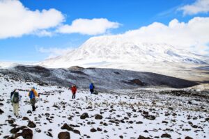 three hikers walking the mt kilimanjaro 7 days rongai route trail full of snow hikers