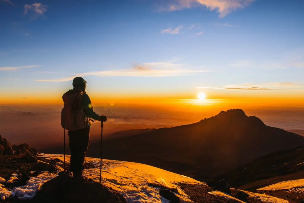 Man looking at Sunrise on Mt. Kilimanjaro peak